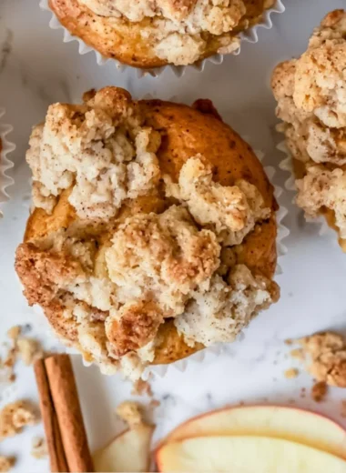Freshly baked cozy apple crumble muffins with crispy topping.