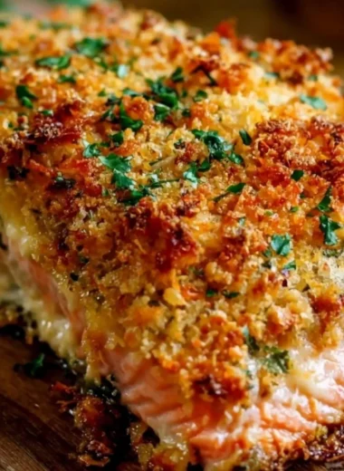 Crispy Parmesan crusted baked salmon on a plate with fresh herbs