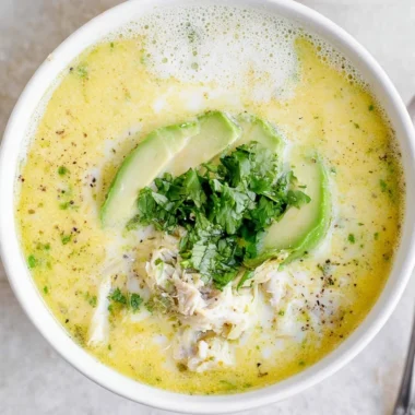 Bowl of creamy white chicken chili garnished with cilantro and lime