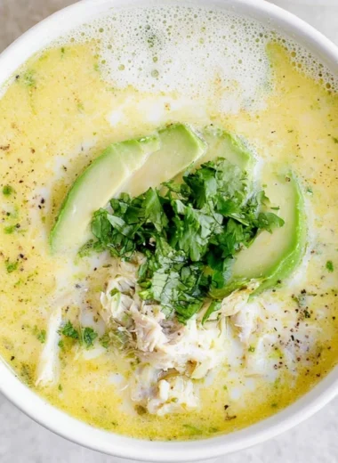 Bowl of creamy white chicken chili garnished with cilantro and lime