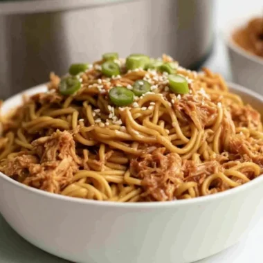 Crockpot honey garlic chicken noodles served with fresh vegetables