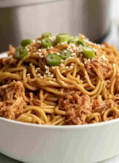 Crockpot honey garlic chicken noodles served with fresh vegetables