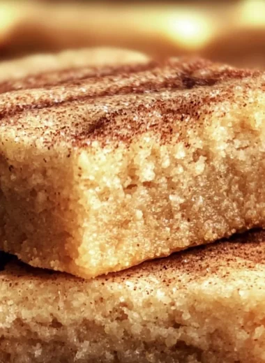 Chewy Snickerdoodle Cookie Bars topped with cinnamon sugar on a rustic plate