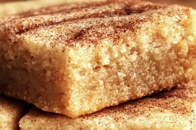 Chewy Snickerdoodle Cookie Bars topped with cinnamon sugar on a rustic plate