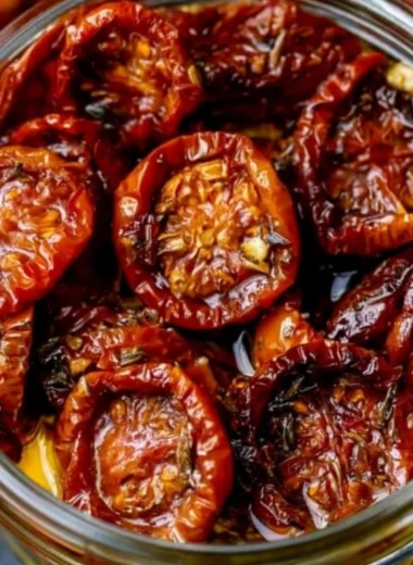 Homemade sun-dried cherry tomatoes in a jar with herbs and spices
